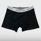 Black Suck My Dick boxer briefs laid flat, front view with a white and grey waistband